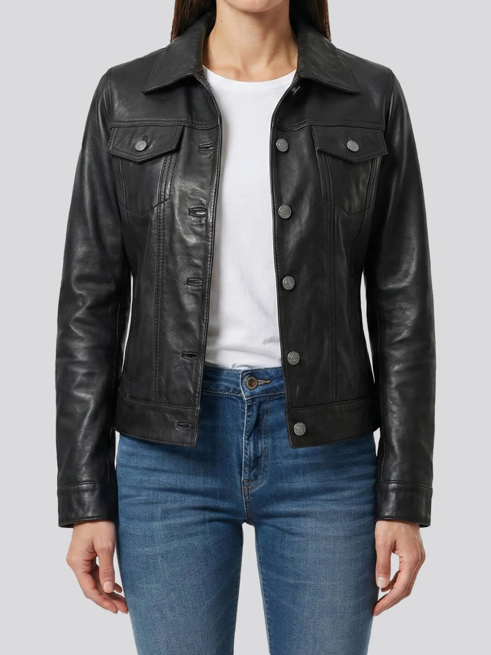 Person wearing a black leather jacket over a white shirt and blue jeans on a light gray background